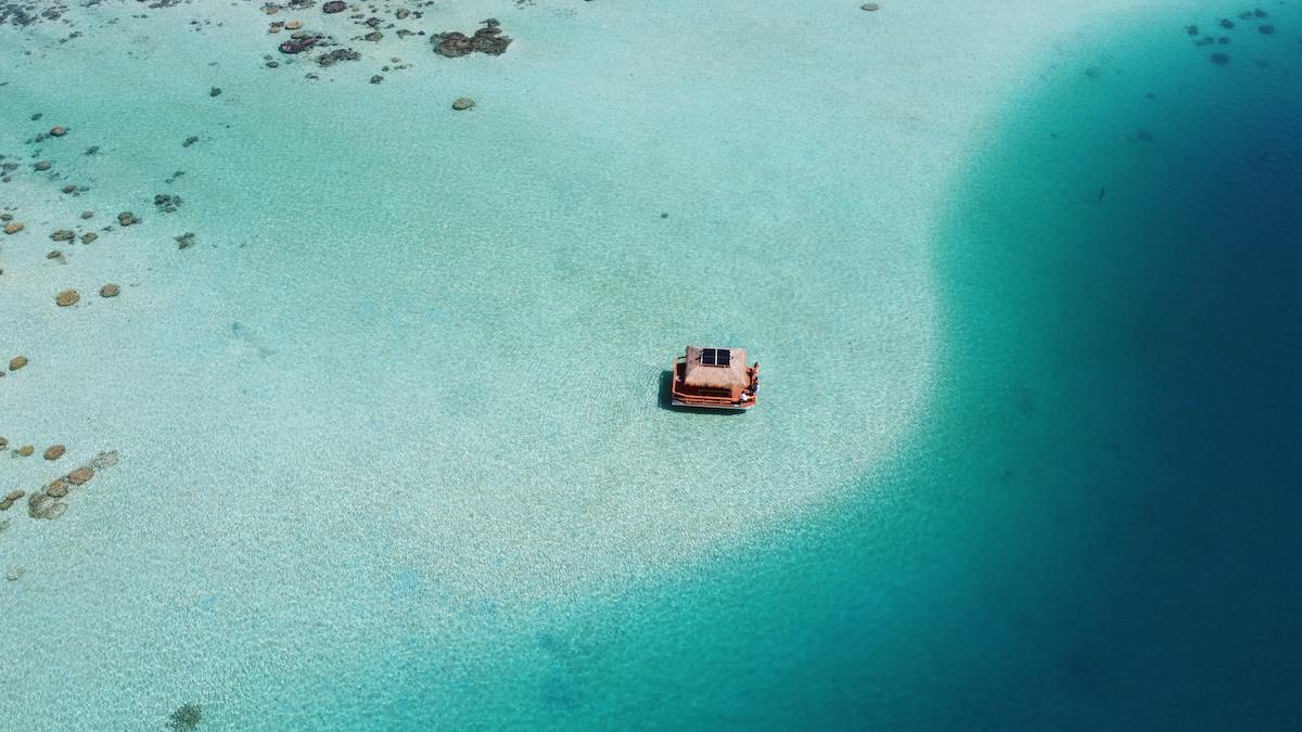 Le Vaimareva vu du ciel, posé sur le banc de sable clair au bord du tombant bleu profond